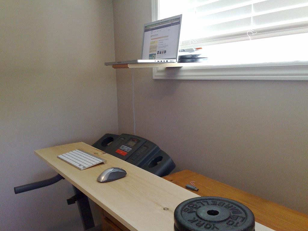 A person using a treadmill desk in a home office with various active workspace elements